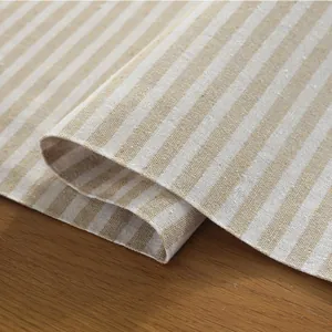 Close-up of beige and light brown striped cotton linen table runner with woven texture