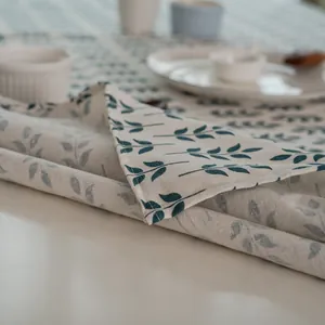 Détail du tissu de nappe en coton et lin avec motif feuilles bleues et couture nette