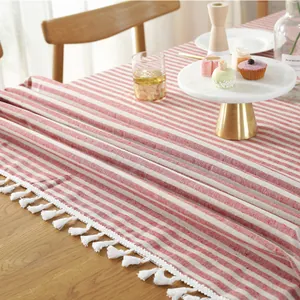 Detail van het rood-wit gestreepte katoen-linnen tafelkleed met decoratieve witte kwastjes