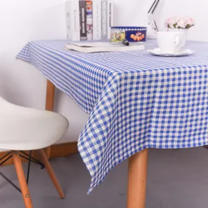 Close-up of blue and white gingham tablecloth with smooth texture on a wooden table