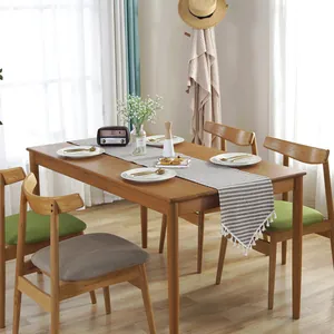Nordic minimalist striped cotton linen table runner with tassels on a wooden dining table