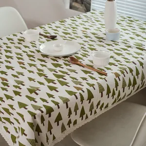 Détail du motif de pins sur nappe en coton et lin avec bordure en dentelle blanche