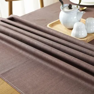 Dettaglio tovaglia in lino marrone scuro impermeabile con cuciture bianche e trama densa