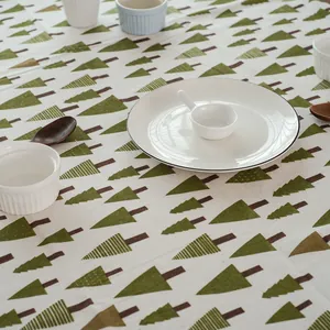 Détail de la nappe en lin avec motifs de sapins verts et texture de tissu souple
