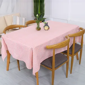 Detail van roze en wit geruit tafelkleed met zachte linnen textuur en drapering