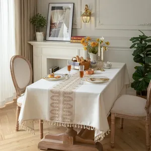 Dettaglio del motivo jacquard vintage e delle frange beige con nappe sulla tovaglia in cotone