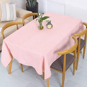 Detail van een roze ruitjes katoenen linnen tafelkleed op een houten eettafel