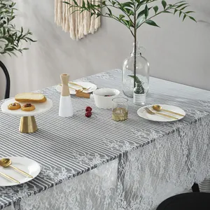 Close-up of grey striped tablecloth with elegant white eyelash lace border trim