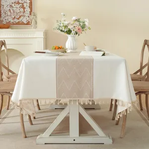 Dettaglio di tovaglia in lino con motivo geometrico marrone e nappe con frange sui bordi