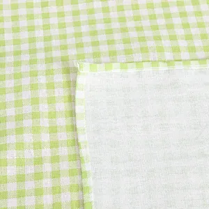 Detailopname van het groen-wit geruite katoenen linnen tafelkleed met strakke zomen