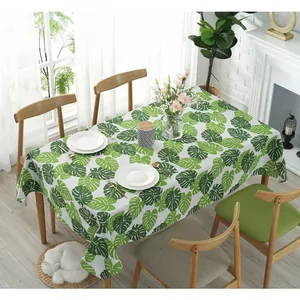 Nordic cotton linen tablecloth featuring green monstera leaves on a white background