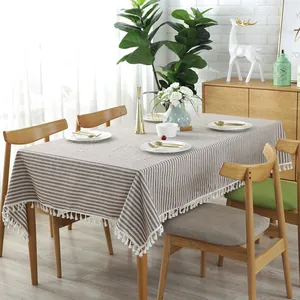 Detail van koffie en wit gestreept linnen tafelkleed met decoratieve witte kwastjes