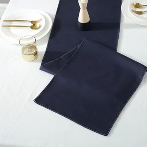 Detail van marineblauwe linnen tafelloper met witte decoratieve stiksels voor eetdecoratie