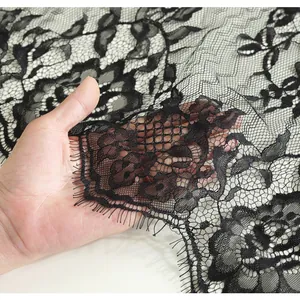 Detail of black floral lace tablecloth with delicate eyelash trim and sheer mesh texture