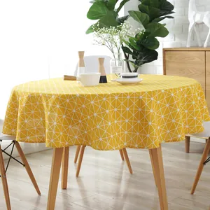 Close-up of yellow cotton linen round tablecloth with white geometric grid patterns