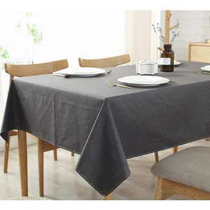 Dettaglio tovaglia in lino grigio scuro impermeabile con cuciture rifinite su legno