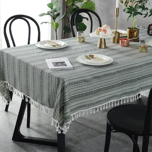 Bohemian striped tablecloth with geometric patterns and white tassels on a dining table