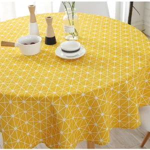 Detail of round cotton linen tablecloth with yellow geometric grid pattern in Nordic style
