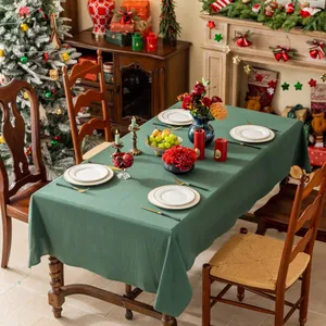 Detailopname van het donkergroene katoenen linnen tafelkleed in een feestelijke kerstsetting