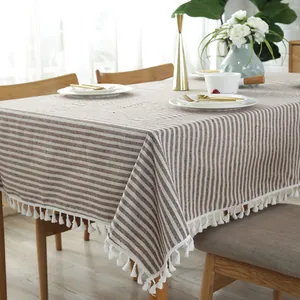 Detail van koffie en wit gestreept linnen tafelkleed met witte decoratieve kwastjes