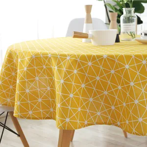 Close-up of yellow cotton linen round tablecloth with white geometric grid pattern