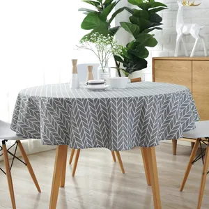 Detail of grey herringbone pattern on round cotton linen tablecloth with neat hemmed edges