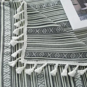 Detail of bohemian geometric woven tablecloth with white tassels and ethnic patterns