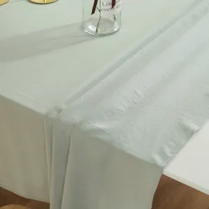 Detail van lichtgroen tafelkleed met rimpeltextuur en nette omgezoomde stiksels