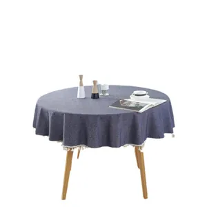 Marineblaue runde Tischdecke mit Leinentextur und weißen Fransen auf einem Holztisch