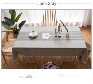 Dettaglio della trama in cotone lino grigio mélange con strisce e nappe bianche decorative