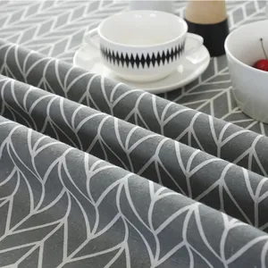 Detail of grey linen tablecloth with white leaf pattern showing fabric texture and drape