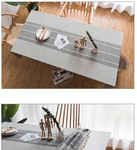 Primo piano della tovaglia in lino grigio con cuciture decorative bianche e trama naturale