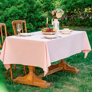 Detailopname van roze katoenen tafelkleed met fijne stoftextuur op een houten tafel