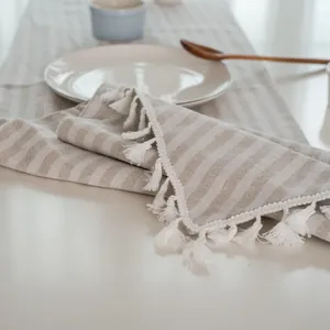 Detail van gestreept linnen tafelkleed met franjes en minimalistische decoratie