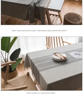 Dettaglio tovaglia in cotone grigio con ricamo a onde bianche e nappine color crema eleganti