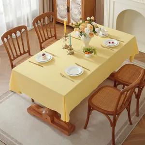 Detail of light yellow cotton tablecloth with fine texture and natural drape on table