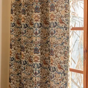 Detail van de textuur van een vintage roos gordijn met vogelpatroon en beige kwastjes