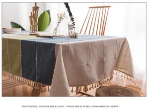 Dettaglio tovaglia in cotone e lino grigio con motivo patchwork e frange con nappe