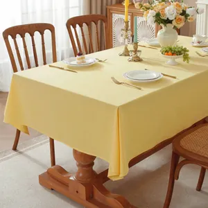 Detailed texture of yellow solid cotton tablecloth in a cozy dining room setting