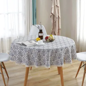Blue vintage patterns round tablecloth with delicate cream lace edging on wooden table