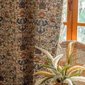 Detail van vintage rode jacquard gordijnen met franjes en elegant bloemenpatroon in licht