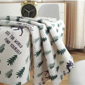 Detail of Nordic cotton linen tablecloth with forest pine trees and reindeer pattern