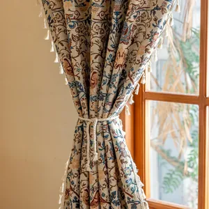 Detailweergave van vintage jacquard gordijn met vogelpatronen en crème kwastjes