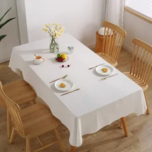 Minimalist white rectangular cotton tablecloth with natural textured finish on a dining table