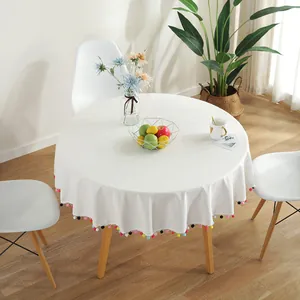 White round tablecloth with colorful pom-pom trim for festive Christmas dining decor