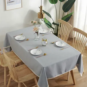 Detail van grijs waterdicht linnen tafelkleed met elegante witte kanten randen op tafel