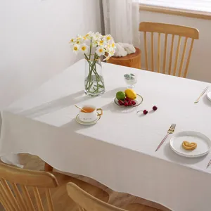 Detail of minimalist white cotton linen tablecloth with natural textured fabric and soft drapes