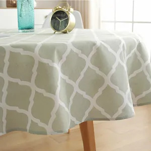 Detail of light green cotton linen tablecloth featuring white Moroccan geometric patterns
