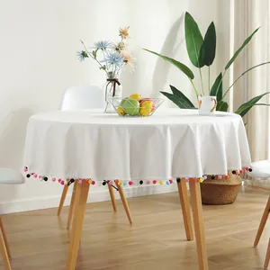 White round cotton linen tablecloth with colorful pom-pom edges for holiday dining decor