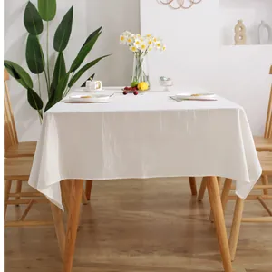 Detail of minimalist cream cotton tablecloth with soft fabric texture in a home setting